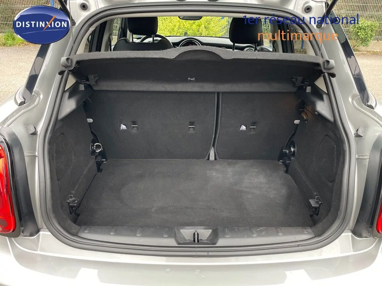 Coffre ouvert d'une MINI 1.5 136CH STEPTRONIC 2023 en Melting Silver Metal, vue arrière montrant l'espace de chargement vide.