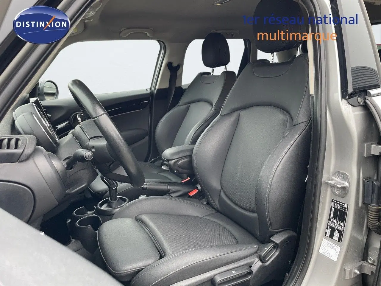 Intérieur de la MINI 2023 en Melting Silver, vue côté gauche sur les sièges avant en cuir noir et tableau de bord.