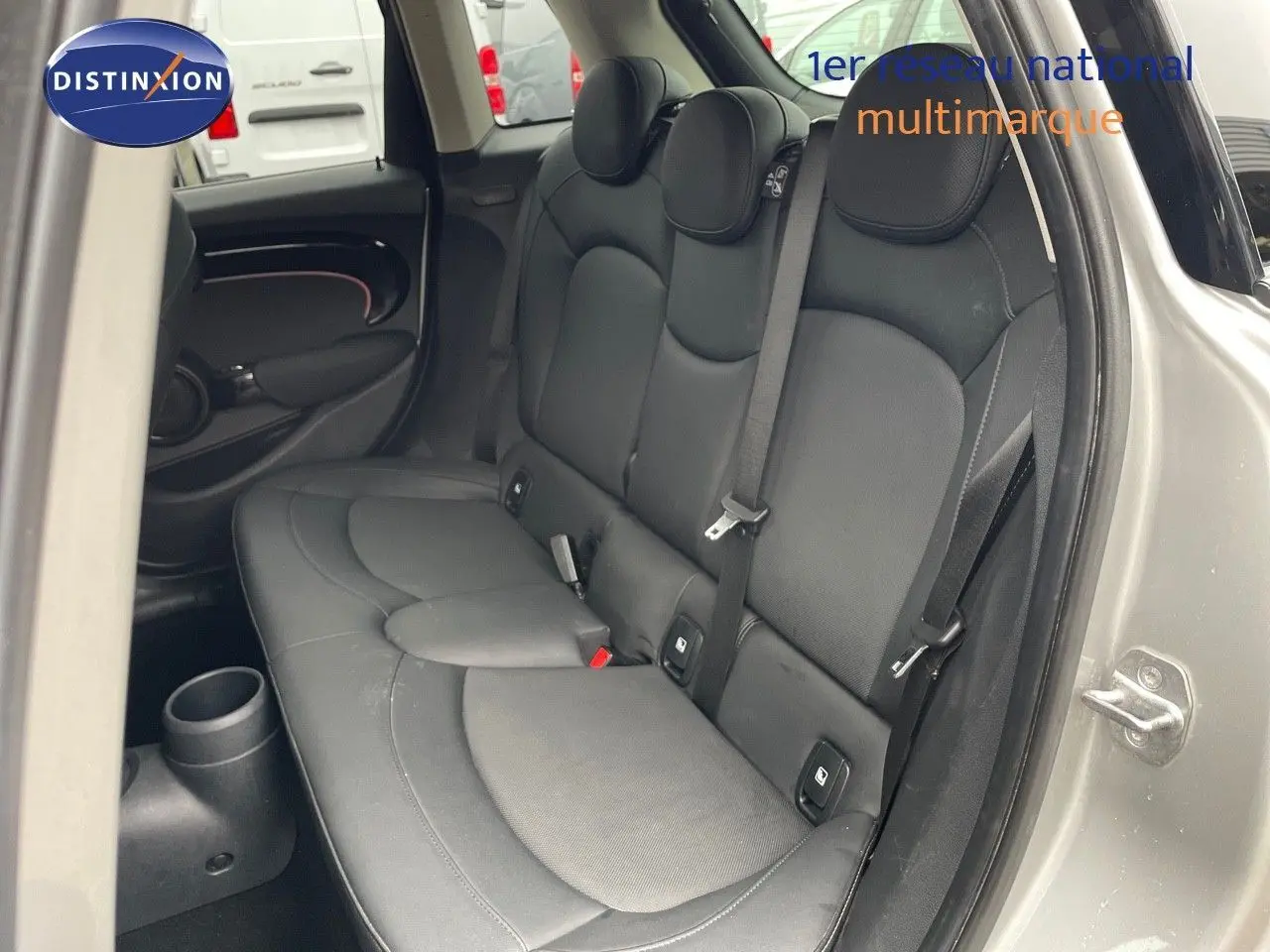 Vue côté droit de l'arrière d'une MINI 2023 Melting Silver avec banquette cuir noir et ceintures visibles.