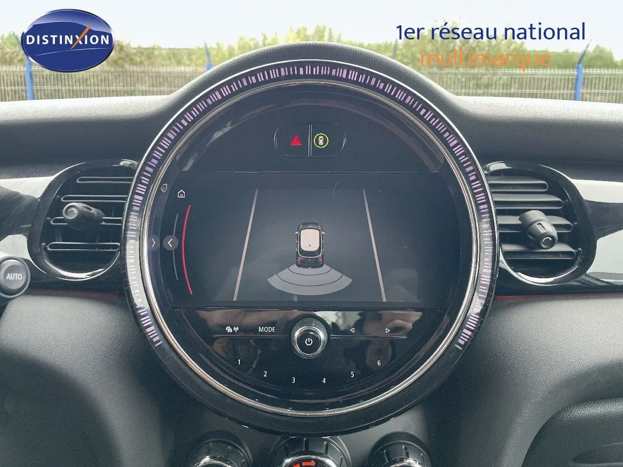Tableau de bord de MINI 1.5 136CH 2023 avec écran central rond affichant l'aide au stationnement.