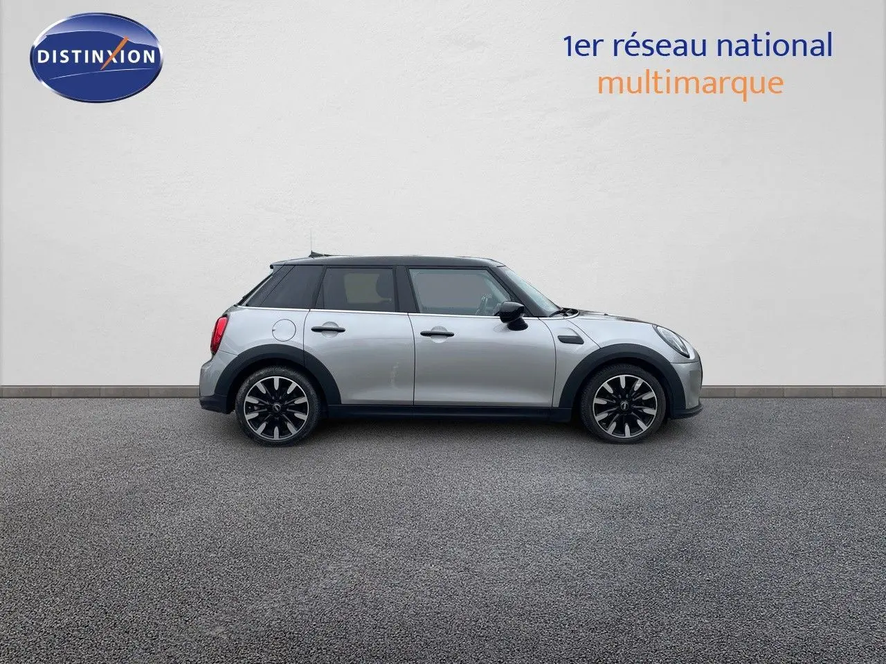 Profil droit d'une MINI 1.5 136CH STEPTRONIC 2023 en Melting Silver Metal avec toit noir et jantes bi-ton.