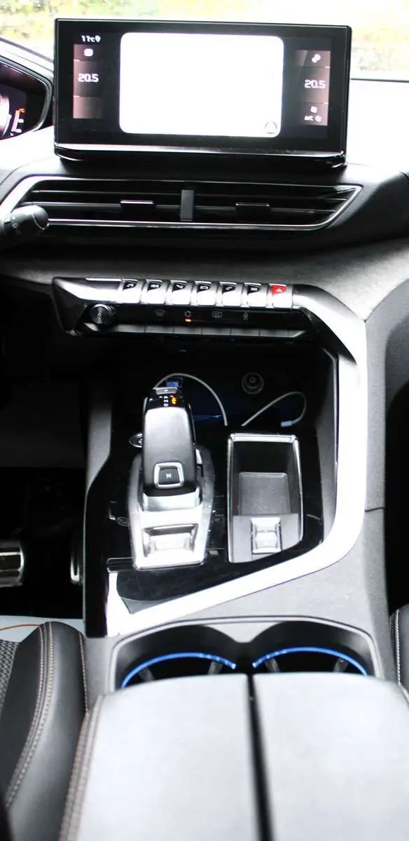 Vue rapprochée de la console centrale du Peugeot 3008 blanc nacré 2025, avec levier de vitesse automatique et écran tactile.