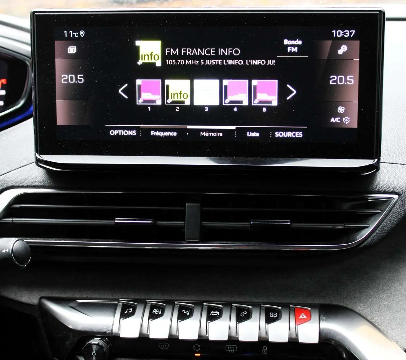 Écran tactile central affichant la radio FM dans l'habitacle noir du Peugeot 3008 blanc nacré 2025.