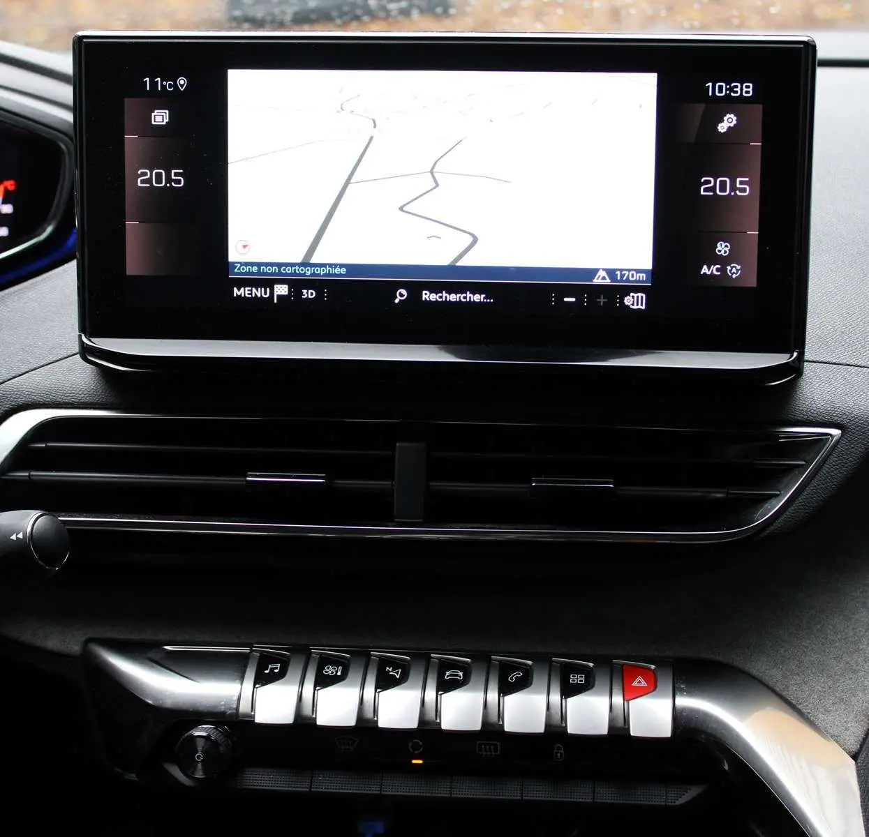 Écran tactile central avec navigation et rangée de commandes chromées sur tableau de bord noir du Peugeot 3008 blanc nacré 2025