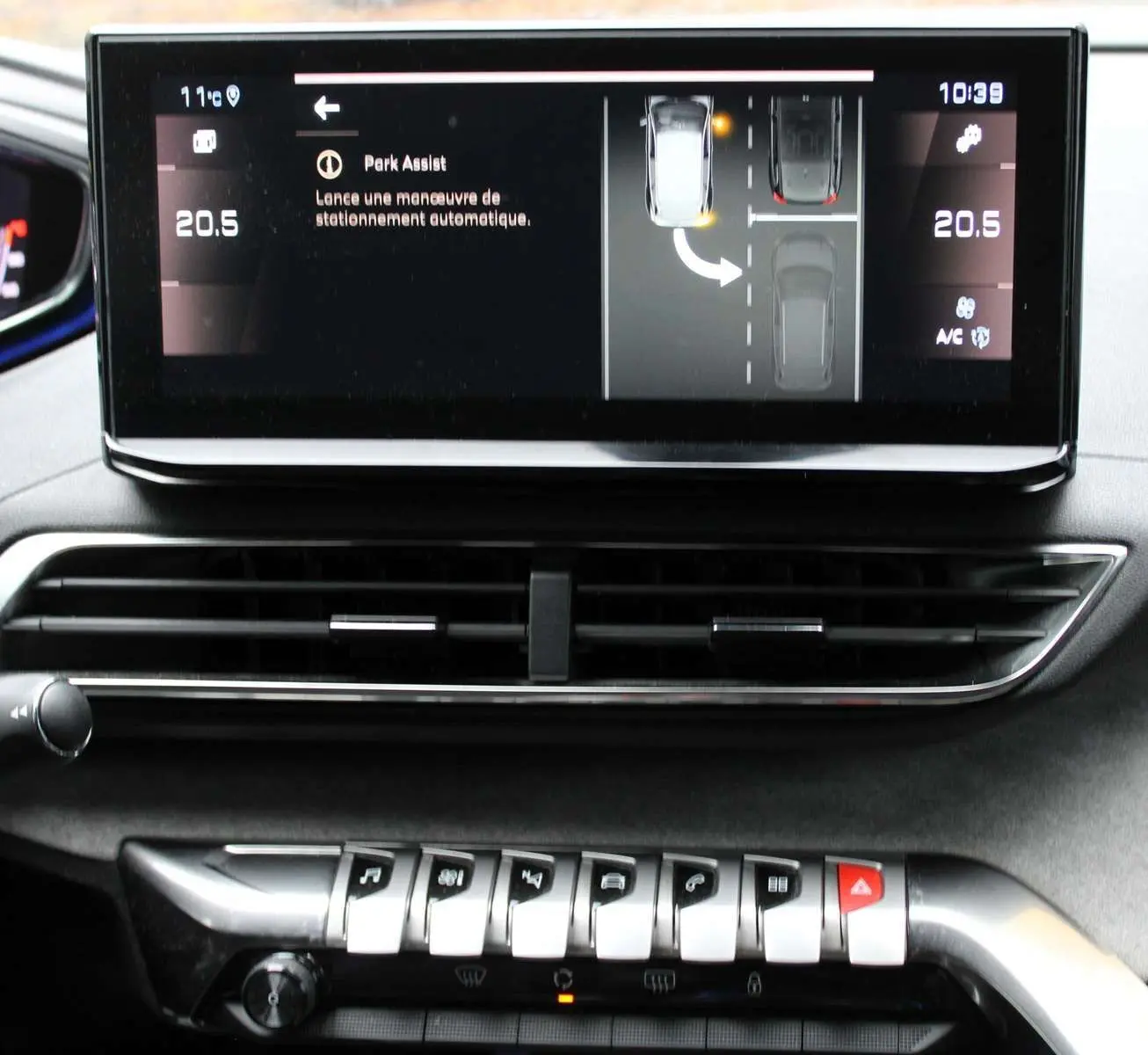 Écran central du tableau de bord du Peugeot 3008 blanc nacré 2025 montrant l'assistance au stationnement automatique.