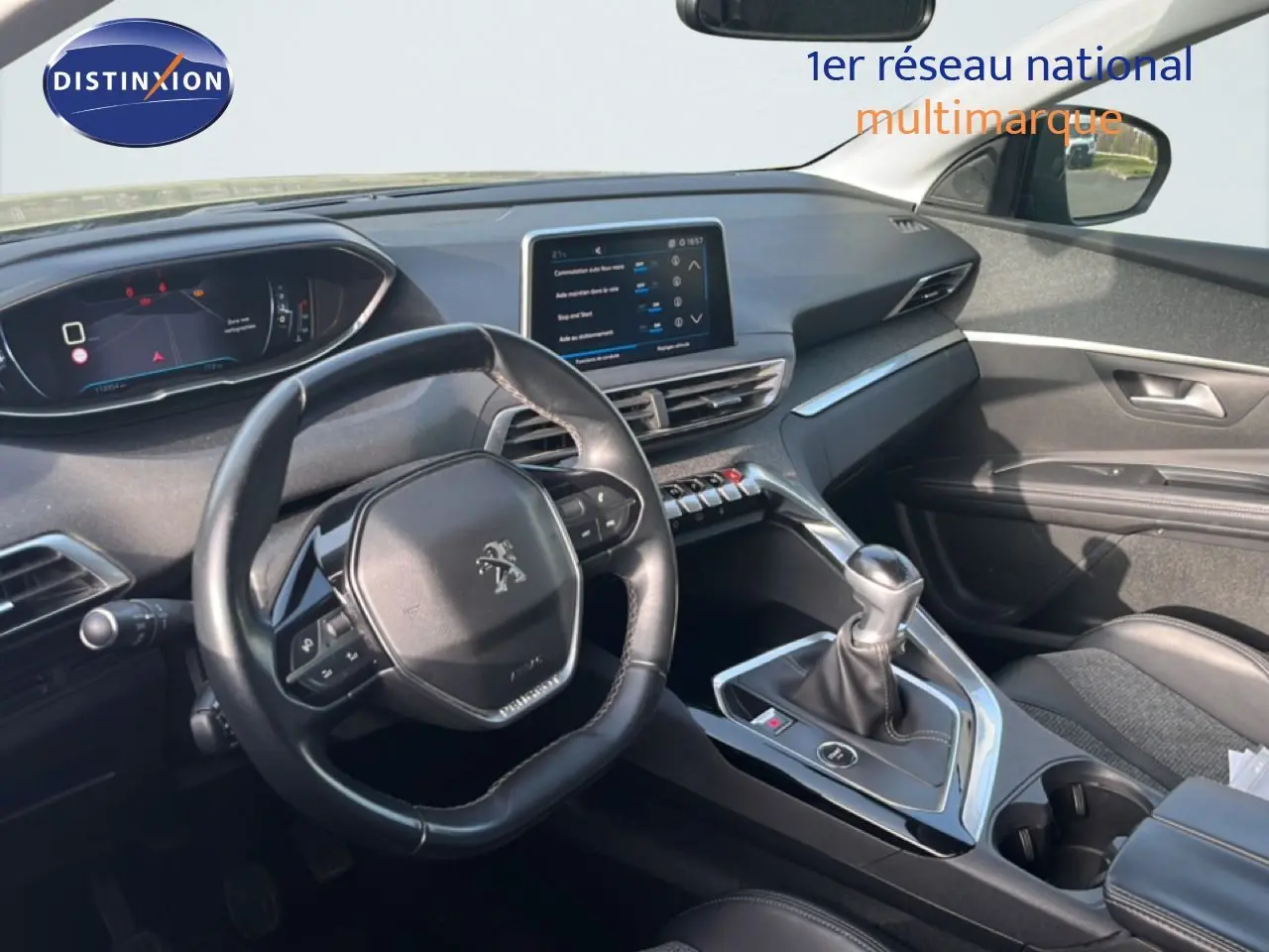 Vue intérieure du poste de conduite du Peugeot 5008 noir Perla Nera, avec volant compact et levier de vitesse manuel.