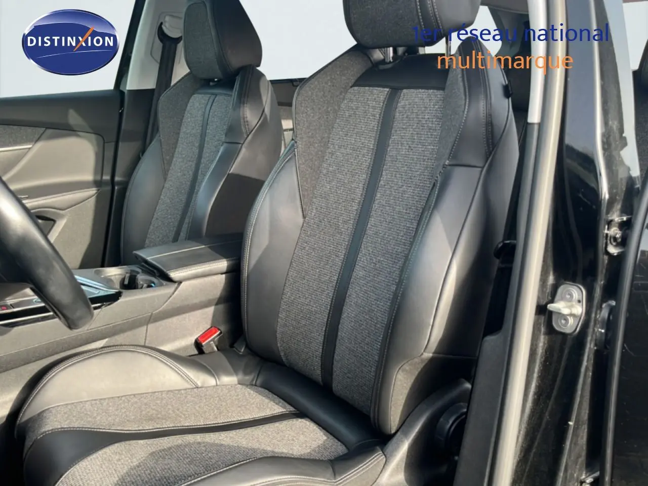 Vue intérieure côté conducteur du Peugeot 5008 noir Perla Nera, mettant en valeur les sièges mixtes tissu gris et cuir noir.