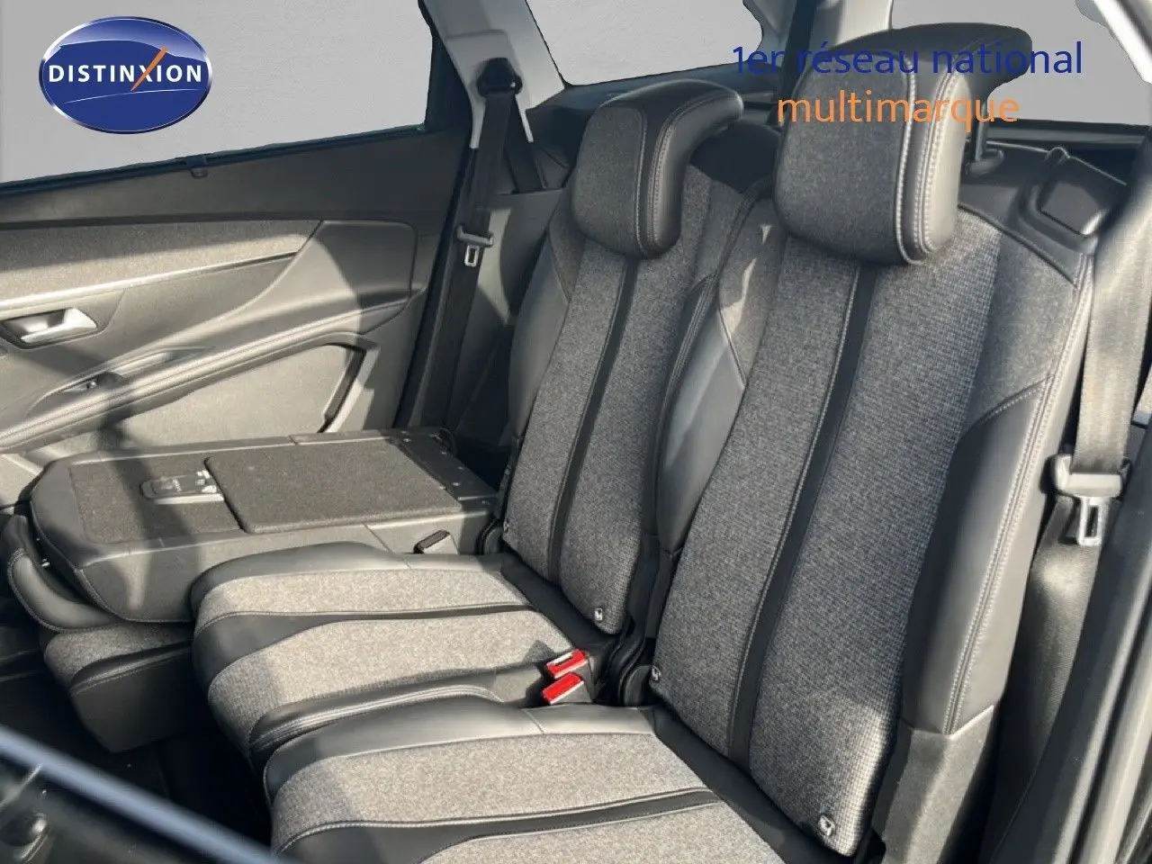 Vue intérieure sur la banquette arrière du Peugeot 5008 2018, tissu gris avec inserts cuir noir et ceintures visibles.