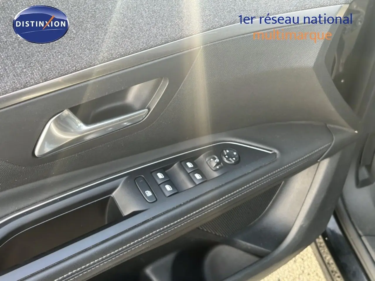 Vue rapprochée de la porte avant gauche de la Peugeot 5008 noire, montrant les commandes des vitres et le bouton de verrouillage.