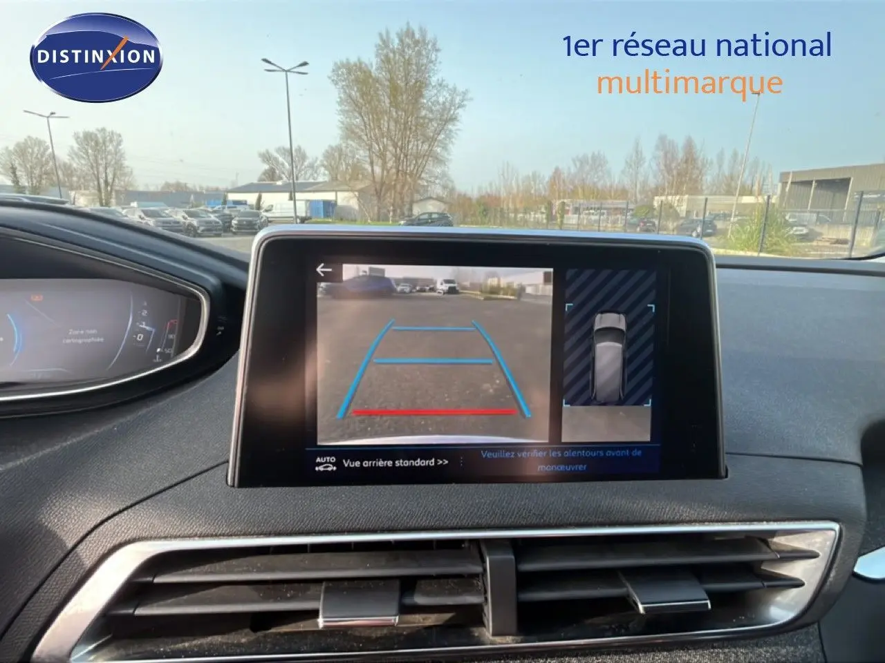 Vue intérieure du tableau de bord du Peugeot 5008 noir, avec écran central affichant la caméra de recul en marche.