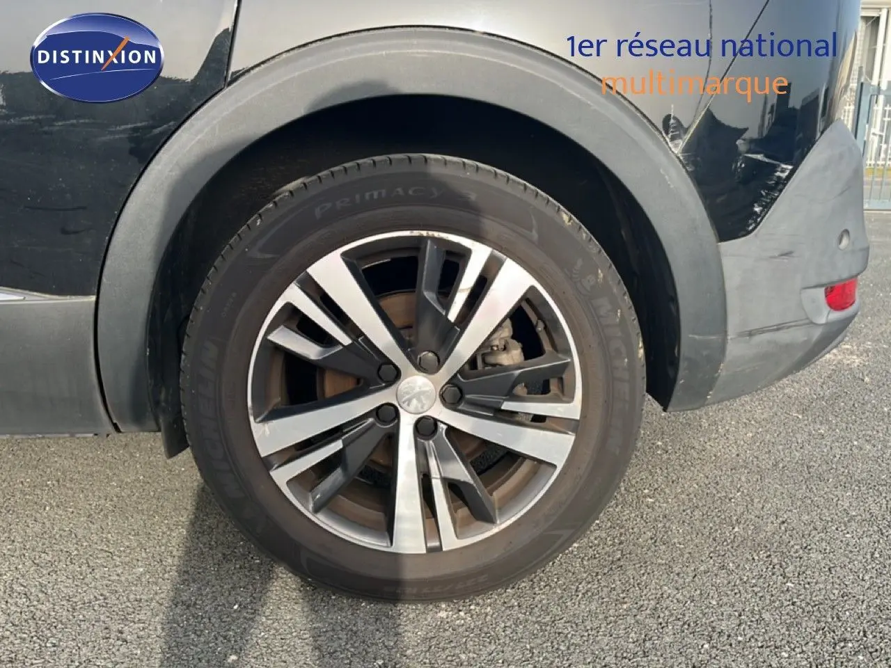 Gros plan sur la roue arrière droite d’un Peugeot 5008 noir Perla Nera, jante alliage bicolore 18 pouces.
