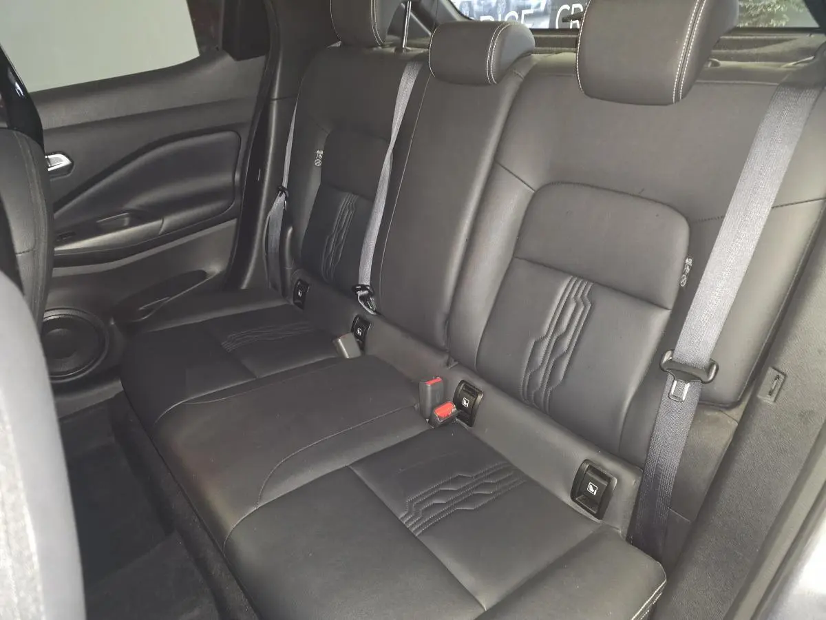 Vue intérieure de la banquette arrière en cuir noir du Nissan Juke 2024, avec ceintures de sécurité et appuis-tête réglables.