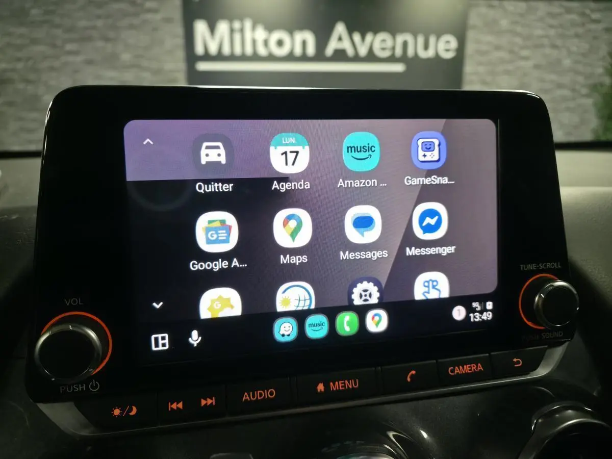 Écran tactile central du Nissan Juke 2024 affichant l'interface multimédia avec commandes physiques éclairées.