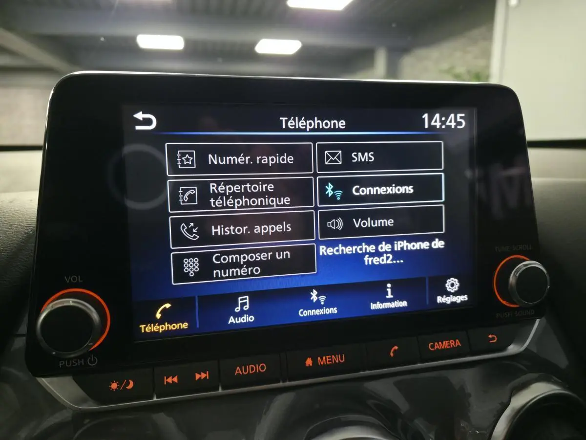 Écran tactile central du Nissan Juke 2024 affichant le menu téléphone avec commandes audio et réglages.