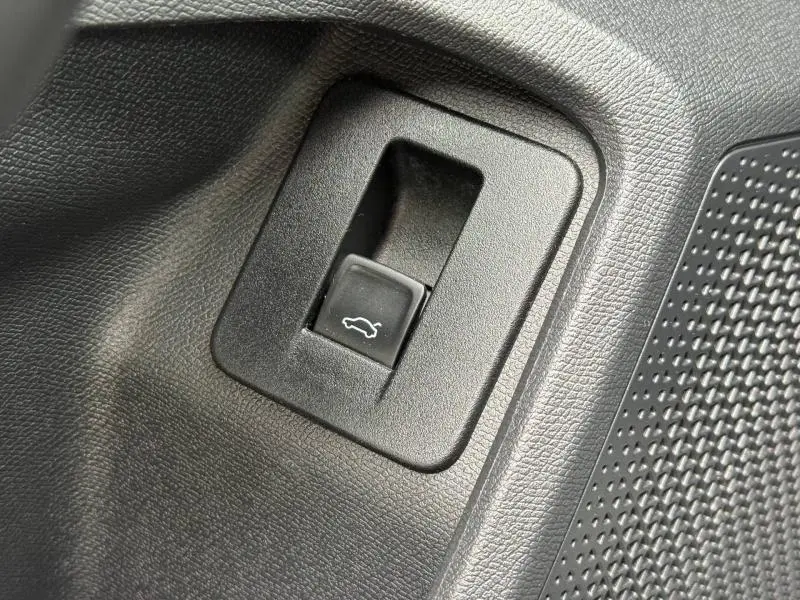 Détail du bouton d'ouverture du coffre dans l'habitacle du CUPRA Formentor 1.5 eTSI Hybrid 2025, finition Gris Magnétique Mat.