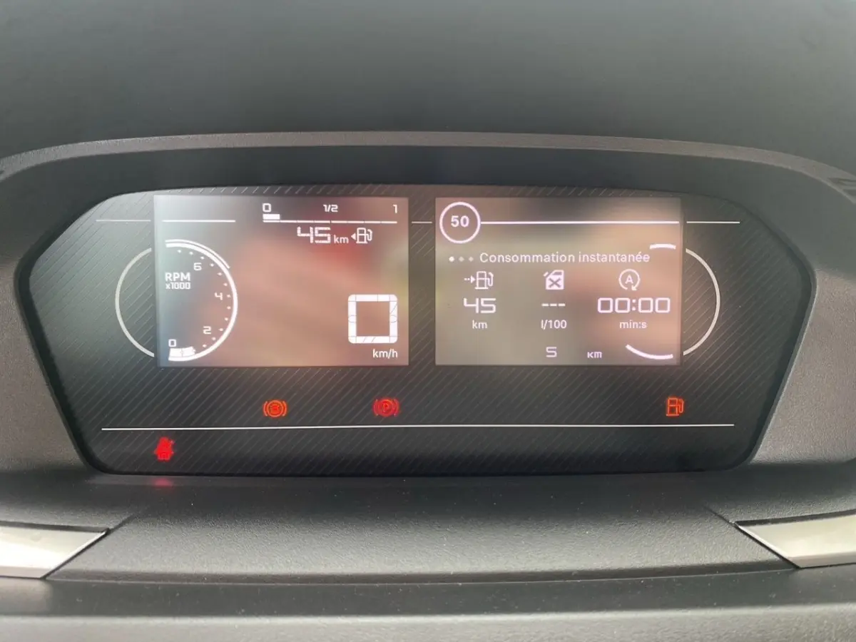 Affichage numérique du combiné d'instruments du Peugeot Partner 2024 montrant vitesse, consommation et alertes.