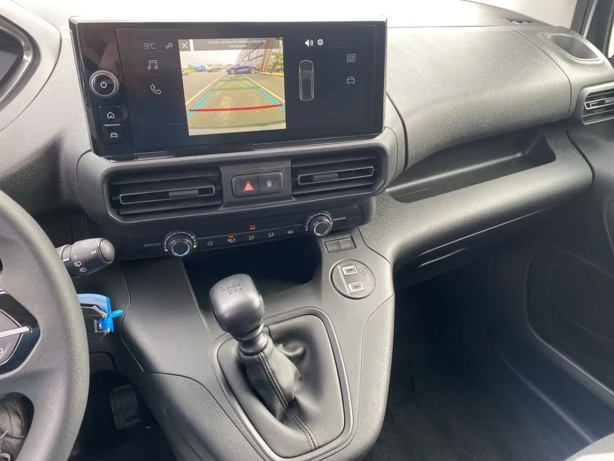 Vue rapprochée de la console centrale du Peugeot Partner 2024, avec écran tactile et levier de vitesses manuel.