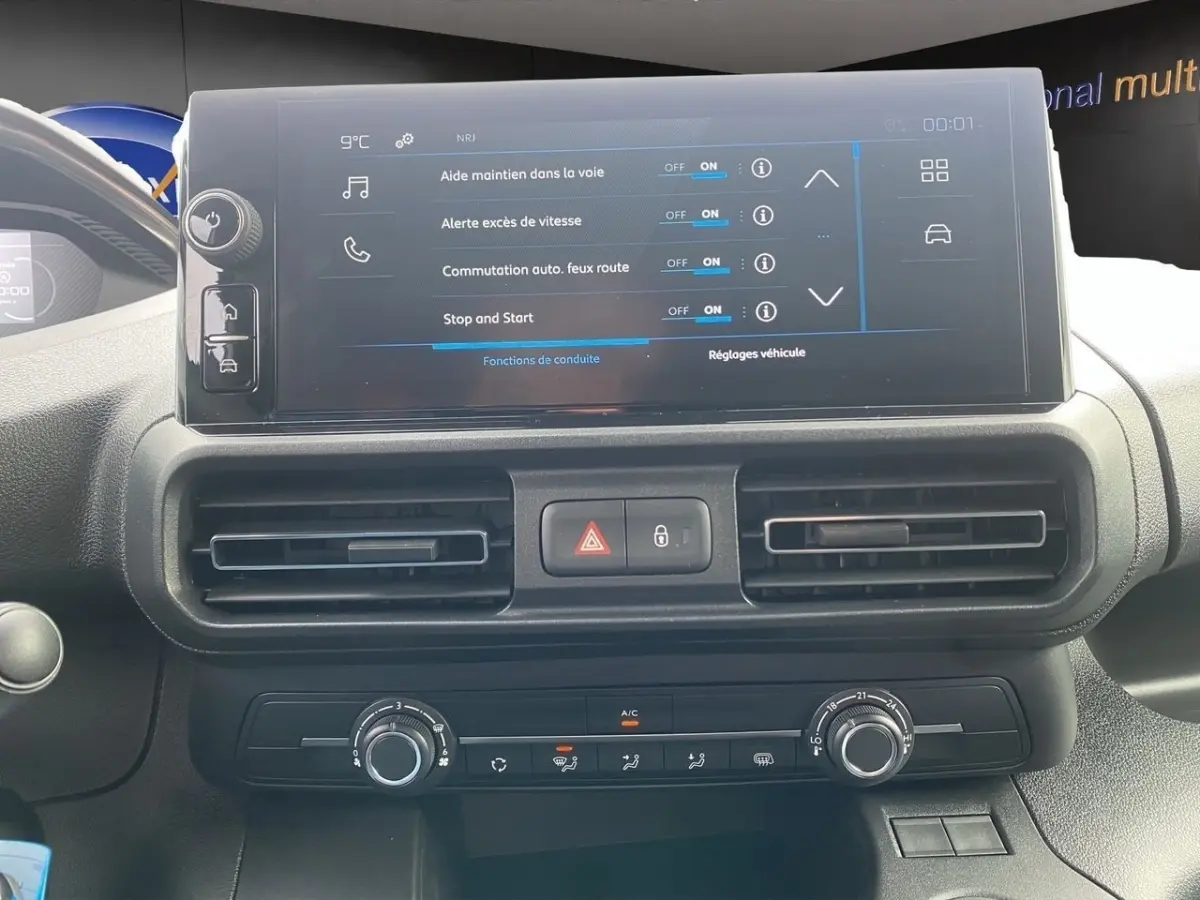 Vue rapprochée de l’écran tactile central et de la console de climatisation du Peugeot Partner blanc 2024.
