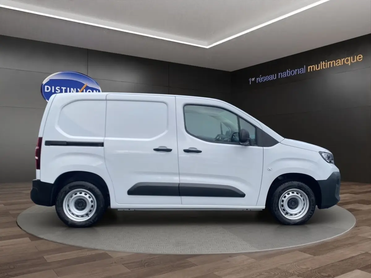 Peugeot Partner blanc en vue profil côté gauche, fourgon utilitaire avec protections noires sur les portes.