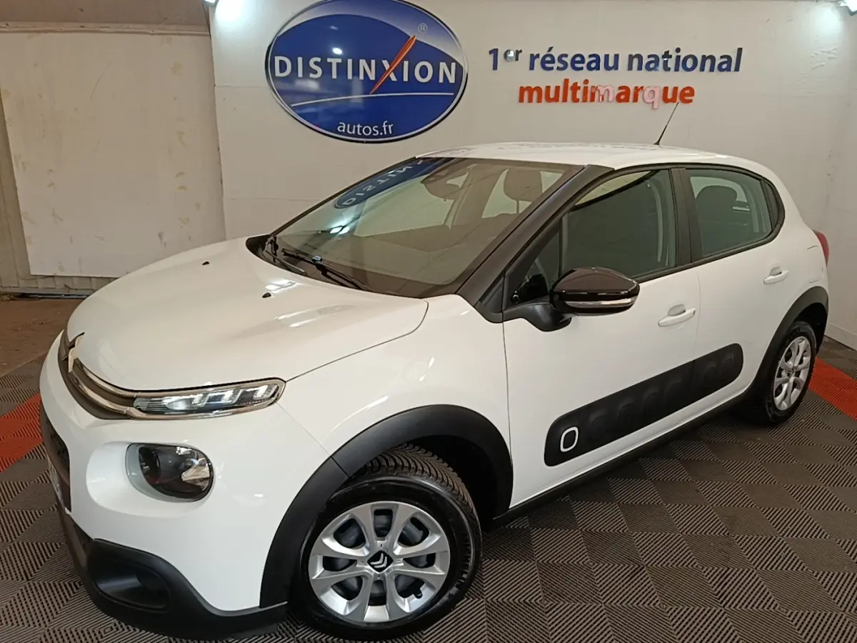 Citroën C3 blanc vue 3/4 avant droit, avec protections latérales noires et jantes alliage.