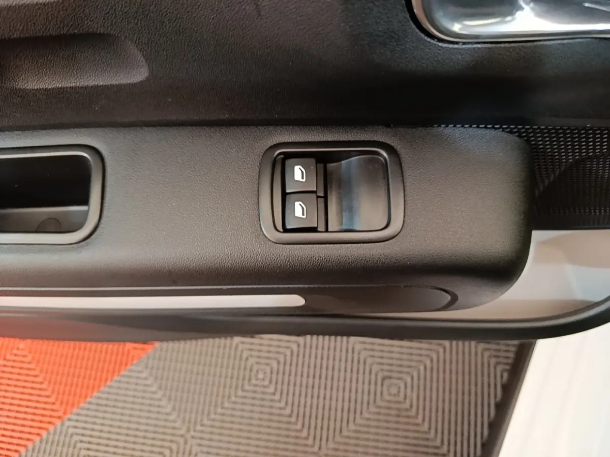 Détail des commandes de lève-vitres sur la porte avant gauche d'une Citroën C3 blanche 2019.