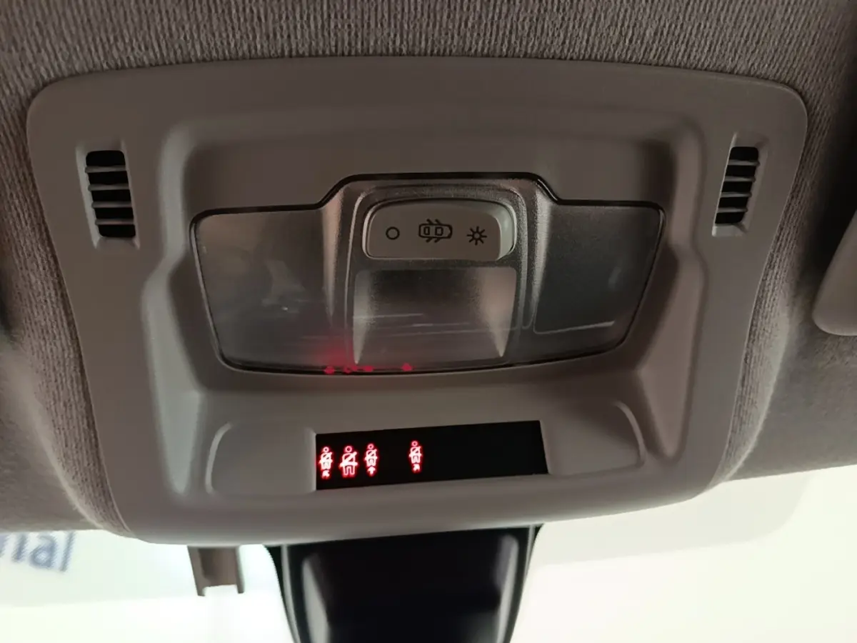 Gros plan sur le plafonnier gris clair de la Citroën C3 blanc, avec éclairage et voyants de ceinture allumés.