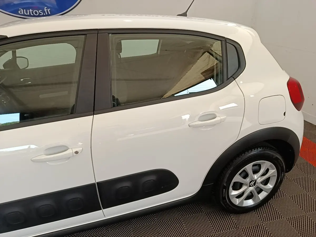 Vue latérale droite d'une Citroën C3 blanche de 2019 avec protections noires sur les portières et jantes argentées.