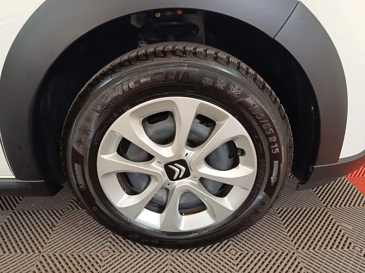 Gros plan sur la roue avant droite d'une Citroën C3 blanche avec jante alliage et pneu Michelin hiver.