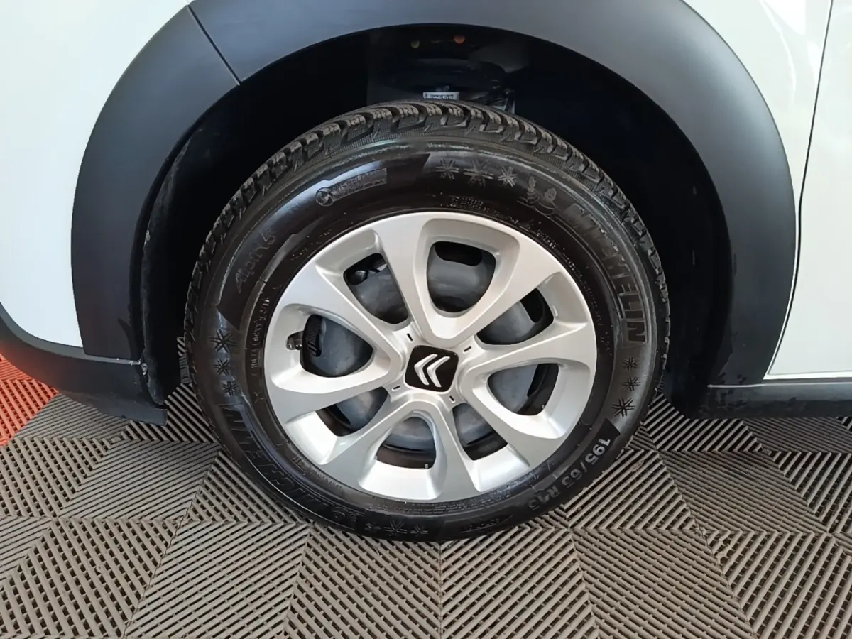 Gros plan sur la roue avant droite d'une Citroën C3 blanche avec jante alliage et pneu Michelin.