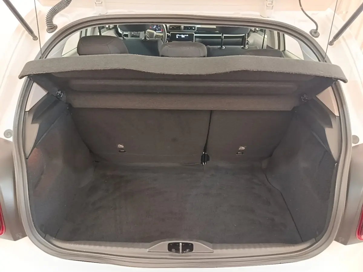 Coffre ouvert vu de l'arrière d'une Citroën C3 blanche, montrant l'espace de chargement et la tablette arrière.
