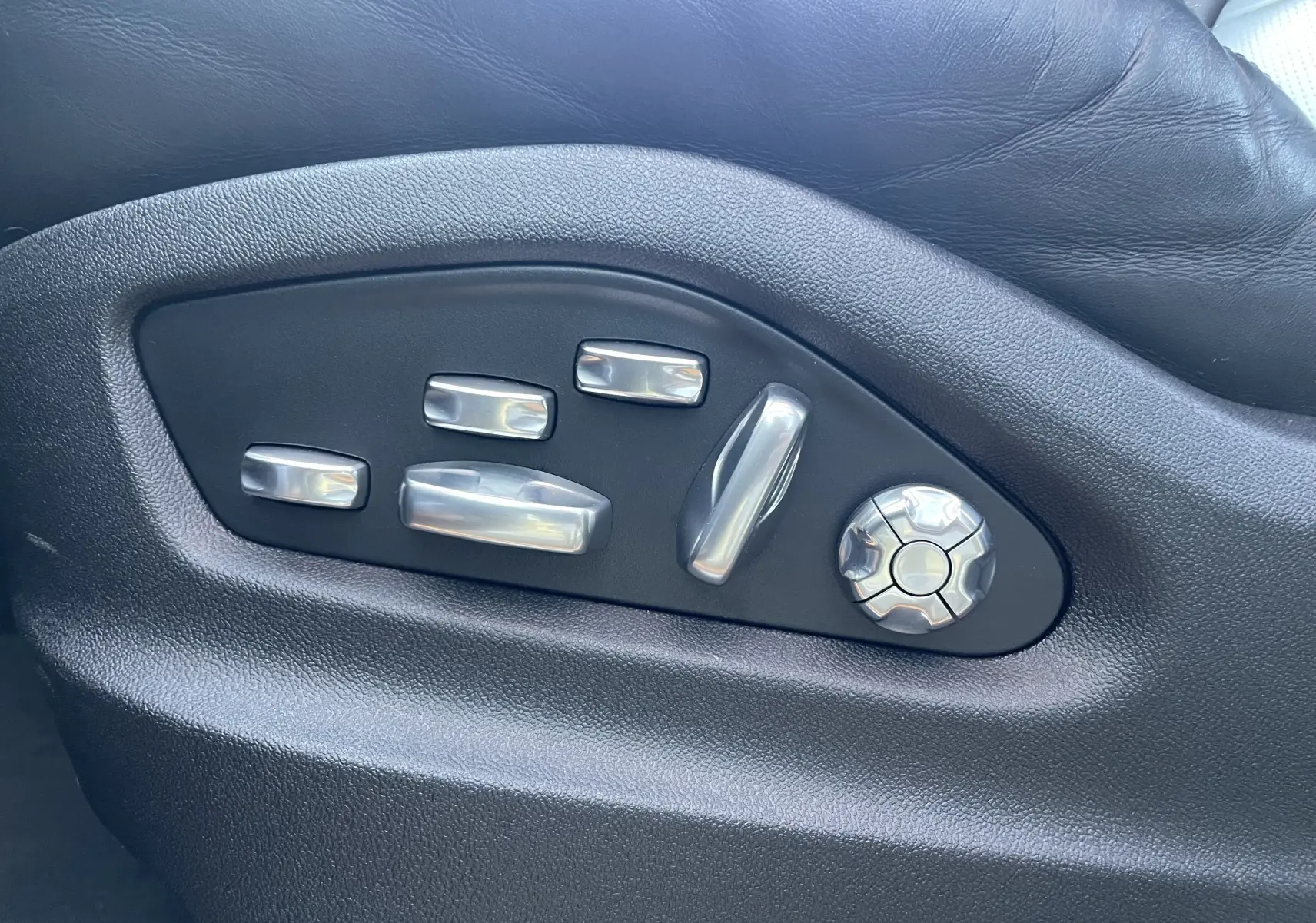 Gros plan sur les commandes de réglage électrique du siège en cuir noir du Porsche Cayenne E-Hybrid 2018.
