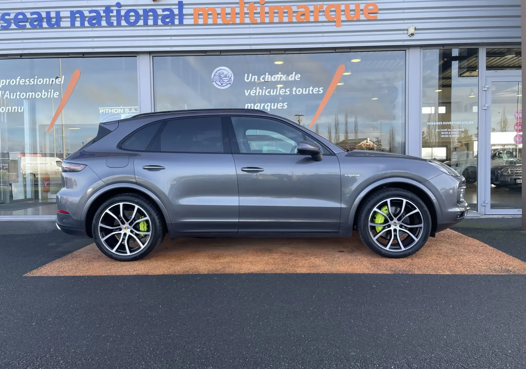Vue de profil droit d’un Porsche Cayenne E-Hybrid 462 BVA gris Kerguelen avec étriers de frein verts visibles.