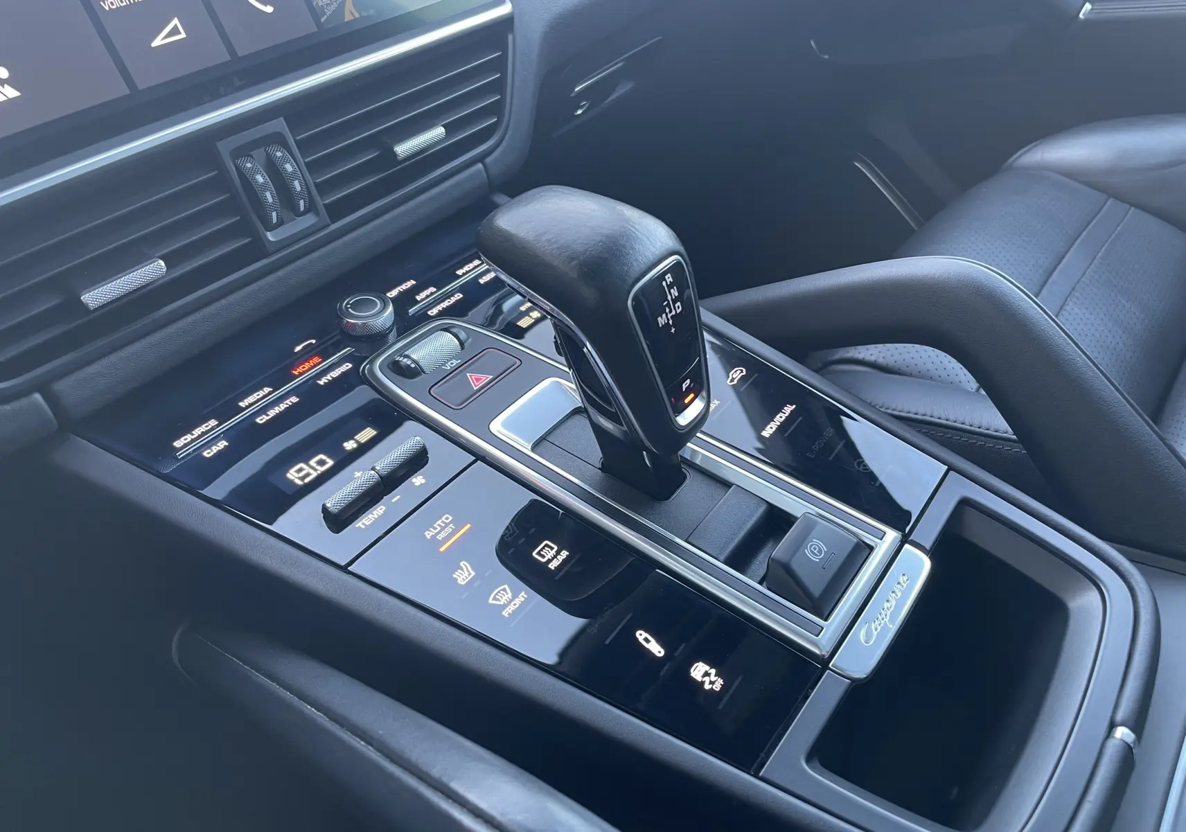 Vue rapprochée de la console centrale du Porsche Cayenne E-Hybrid 2018 avec levier de vitesse et commandes tactiles en noir brillant.