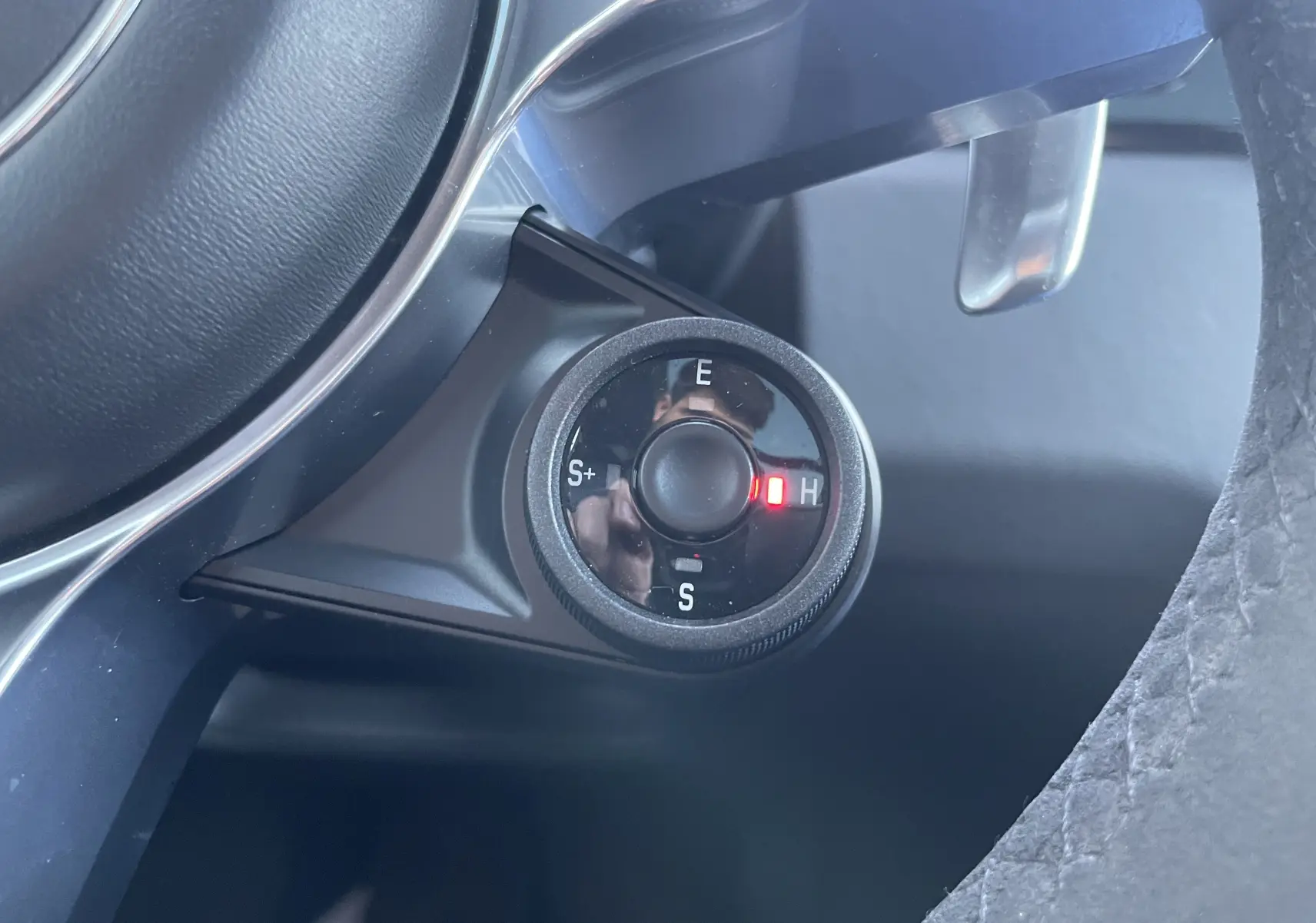 Gros plan sur la molette de sélection de mode de conduite du Porsche Cayenne E-Hybrid 2018, avec éclairage rouge sur mode H.