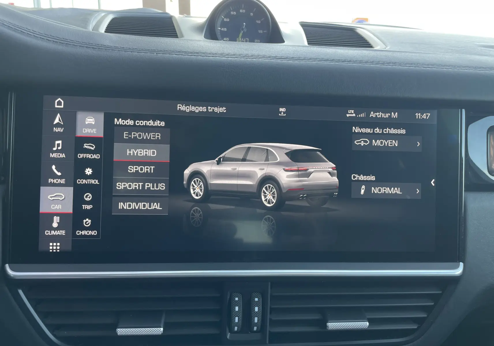 Vue intérieure du tableau de bord du Porsche Cayenne E-Hybrid 2018 avec l'écran tactile affichant les modes de conduite et réglages du châssis.