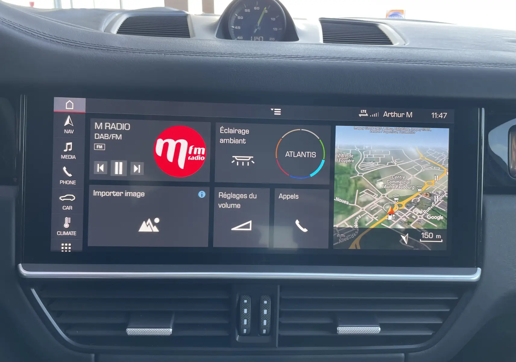 Vue rapprochée de l’écran tactile central du Porsche Cayenne E-Hybrid 2018 en Gris Kerguelen, affichant navigation et radio.