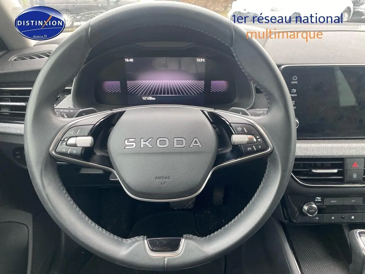 Vue intérieure centrée sur le volant cuir noir SKODA du KAMIQ 2025 avec tableau de bord numérique et écran tactile.