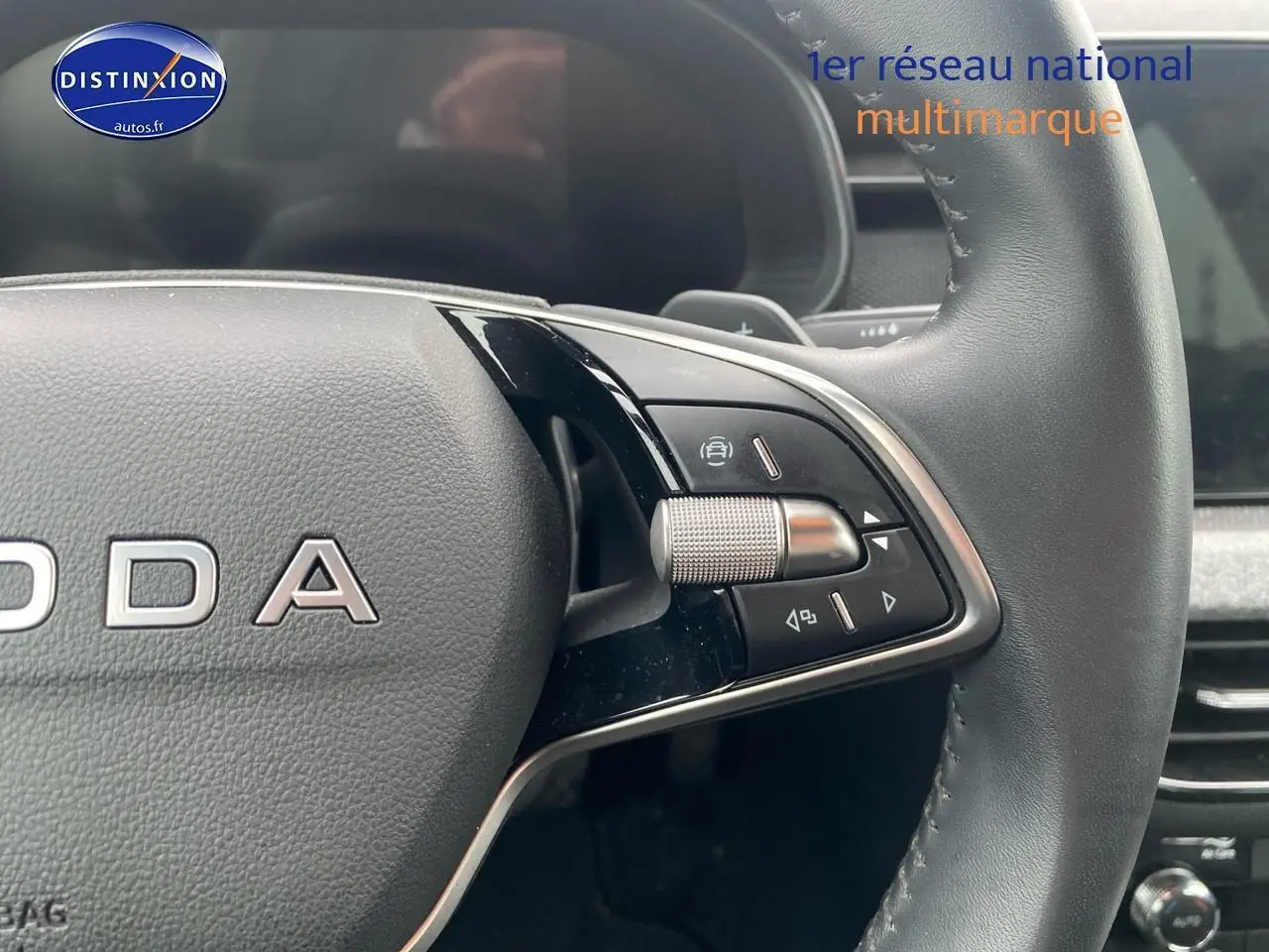 Gros plan sur le volant cuir noir de la Skoda Kamiq 2025, avec commandes multifonctions et molette de réglage.