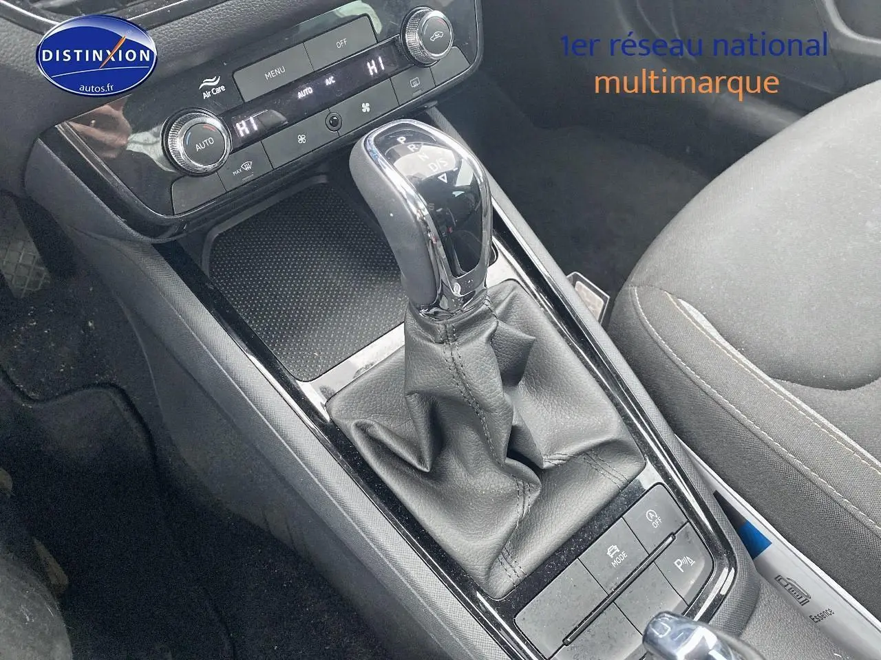 Gros plan sur la console centrale noire du Skoda Kamiq 2025 avec levier de vitesses automatique et commandes de climatisation.