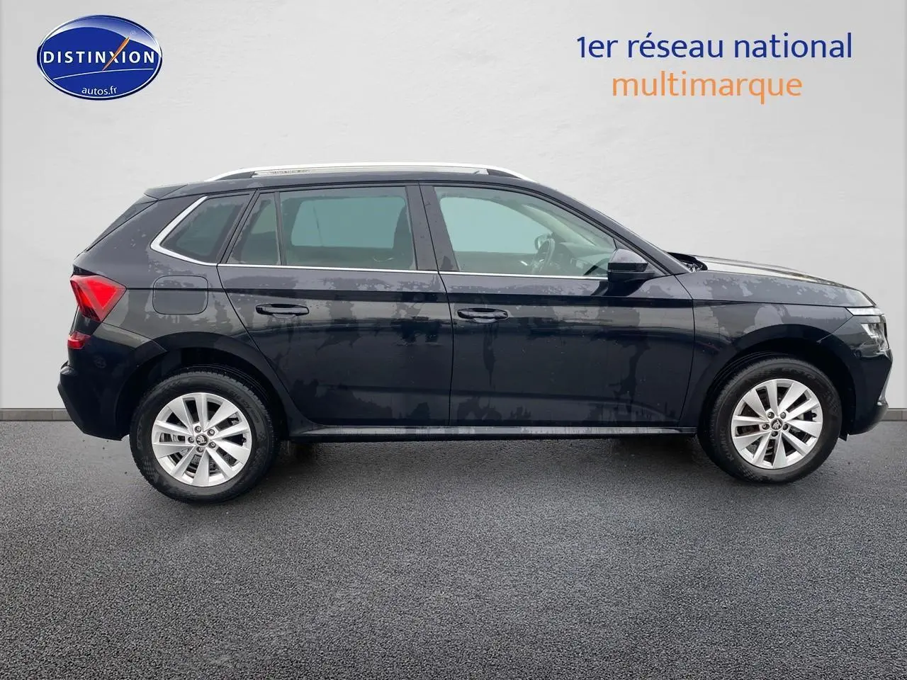 Vue de profil côté gauche d'un Skoda Kamiq noir 2025 avec jantes alu et barres de toit visibles.