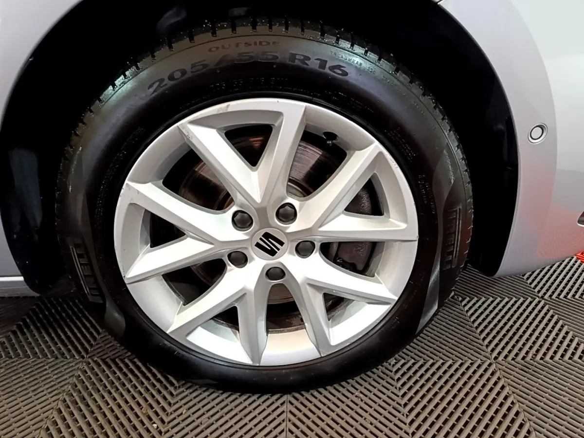 Gros plan sur la jante alliage argentée de 16 pouces avec logo SEAT sur roue avant droite d'une SEAT Leon gris foncé.