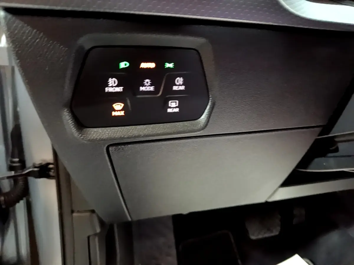 Vue intérieure côté conducteur du tableau de bord noir avec commandes d’éclairage et désembuage du SEAT Leon gris foncé.