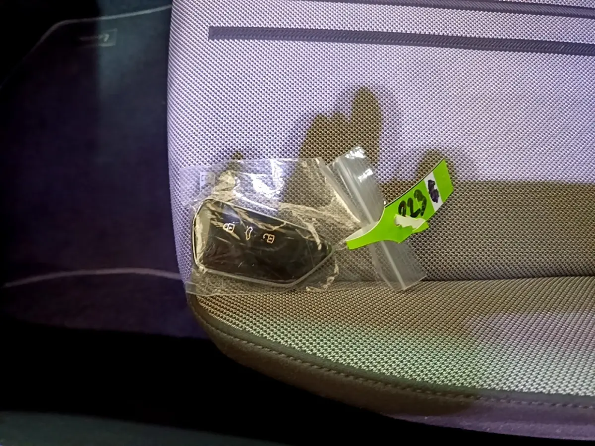 Clé de voiture SEAT Leon 2022 dans un sachet plastique posée sur un siège tissu gris clair.