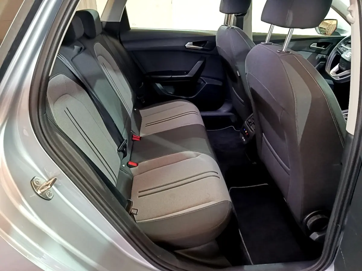 Vue intérieure côté gauche sur la banquette arrière grise du SEAT LEON 2022, avec sièges tissu et détails noirs.