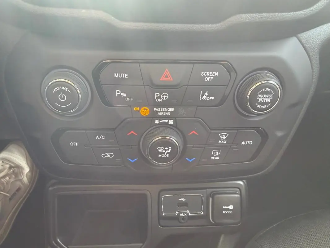 Vue rapprochée du tableau de bord central de la Jeep Renegade 2023, montrant les commandes de climatisation et multimédia.