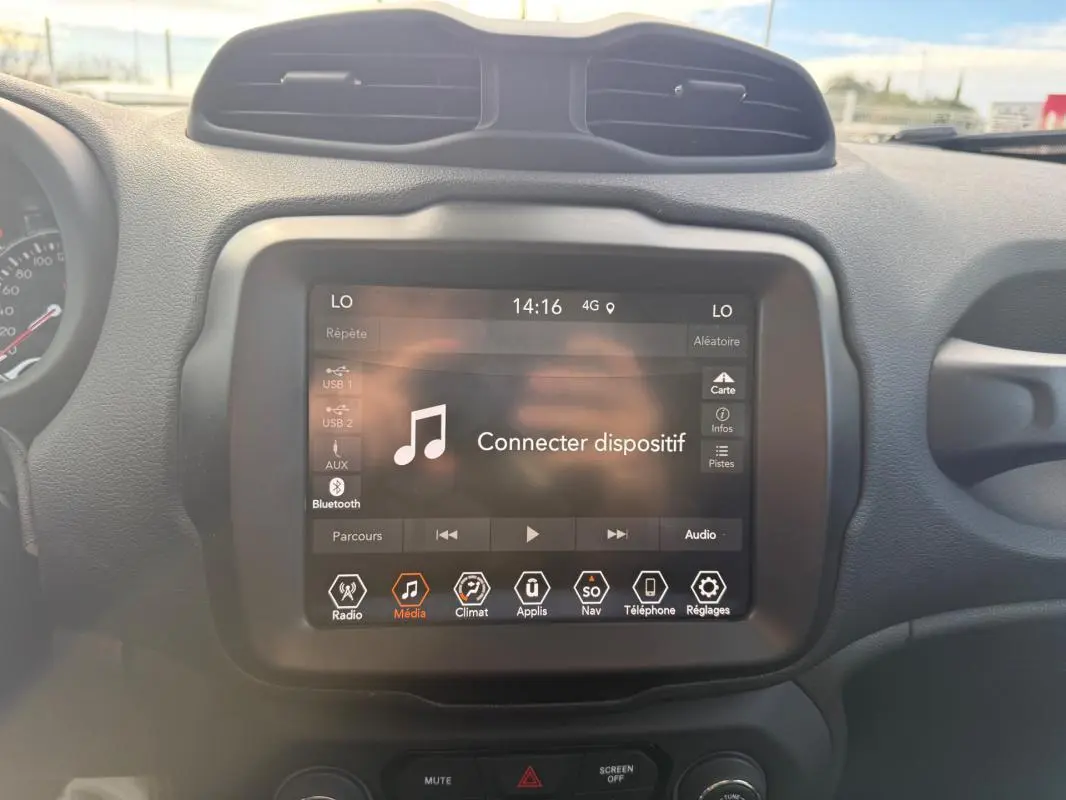 Vue rapprochée de l’écran tactile multimédia du Jeep Renegade bleu 2023 avec interface connectivité Bluetooth affichée.
