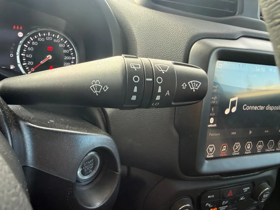 Gros plan sur la commande d’essuie-glace et l’écran tactile du tableau de bord intérieur de la Jeep Renegade 2023.