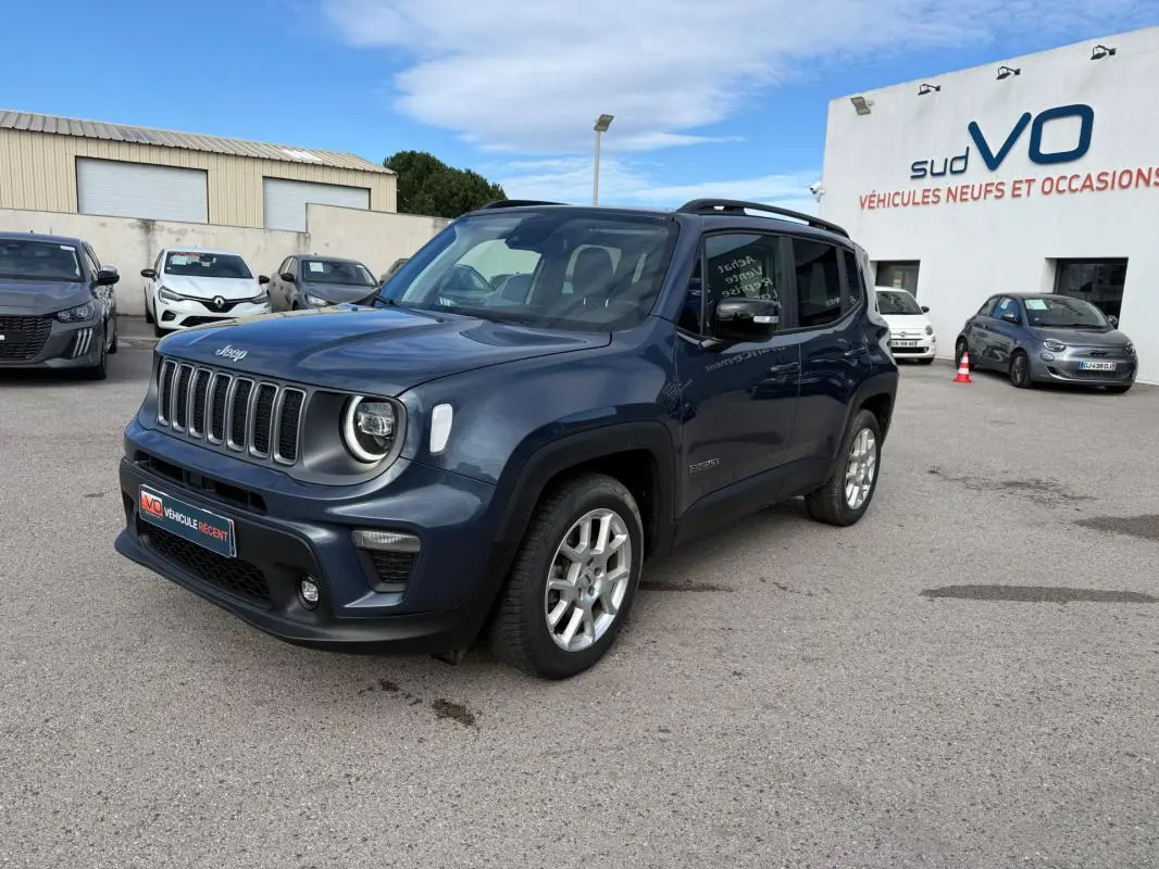 Jeep Renegade bleu en 3/4 avant droit, avec barres de toit et jantes alliage visibles, stationné en extérieur.
