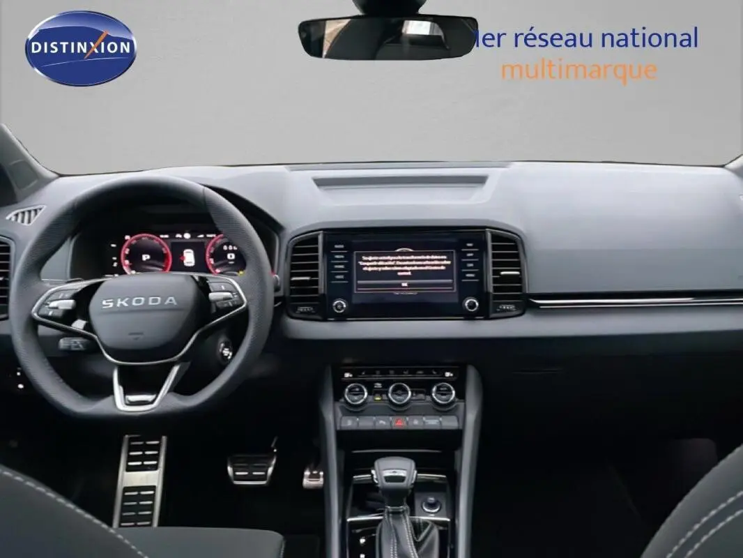 Vue intérieure avant du Skoda Karoq argent 2025, tableau de bord moderne avec écran tactile et volant multifonctions cuir.
