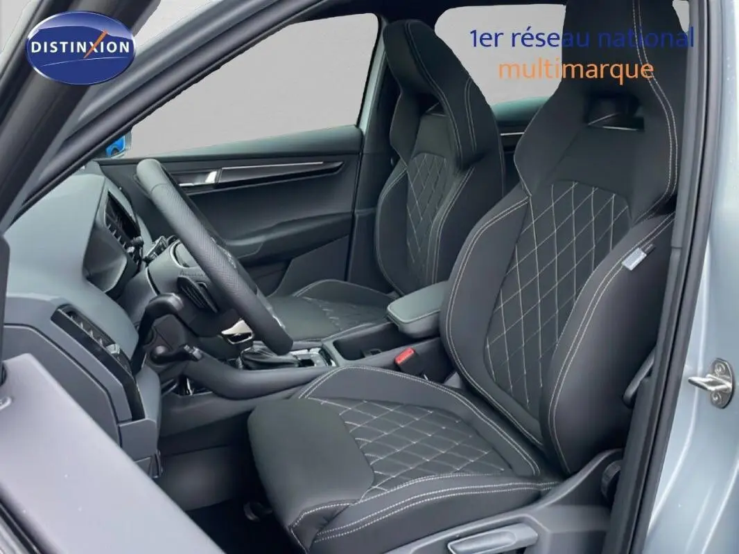 Vue intérieure côté conducteur du Skoda Karoq argent, mettant en valeur les sièges sport noirs avec surpiqûres blanches.